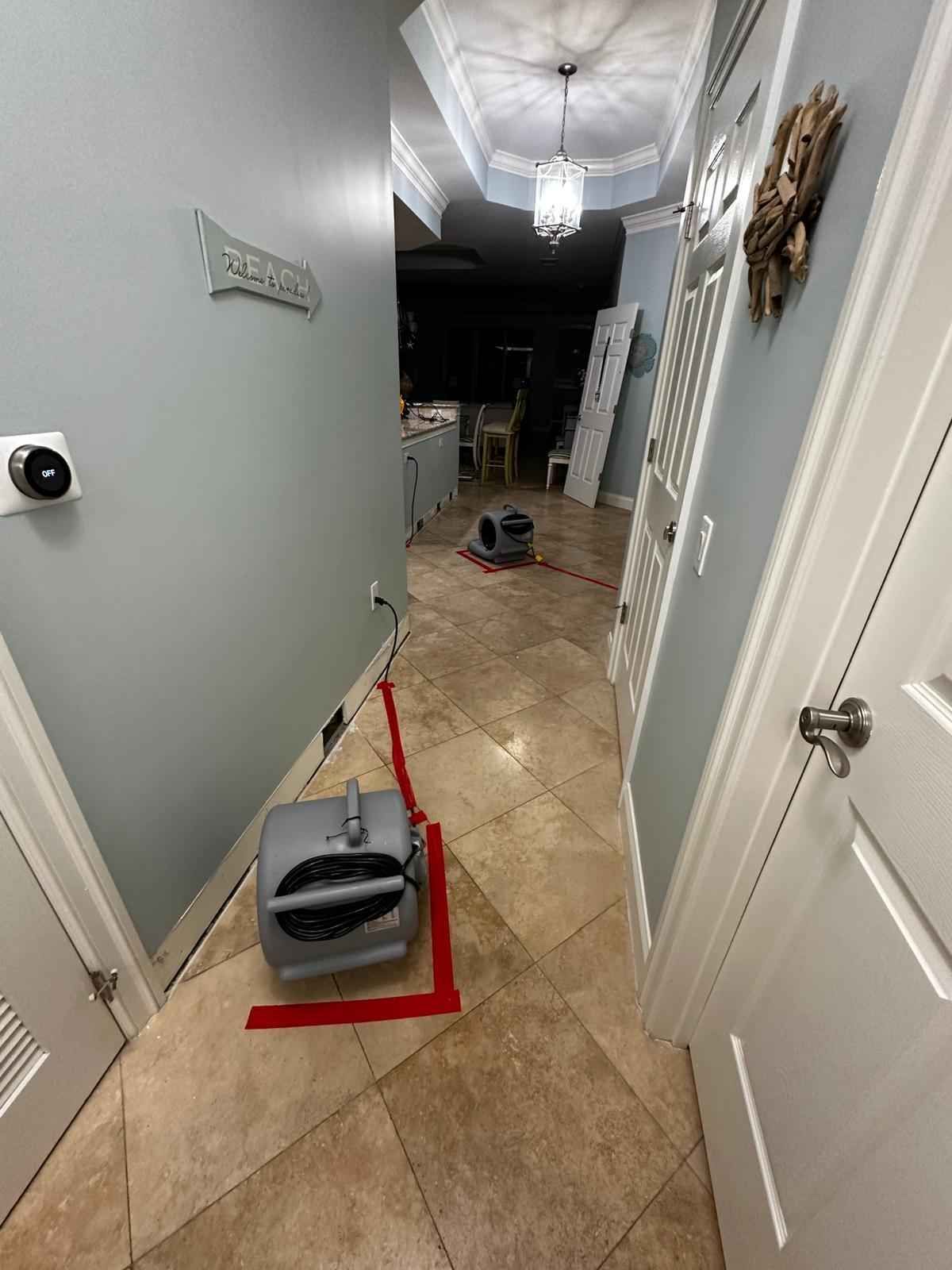 A hallway with a vacuum sitting on the floor in the middle of it.
