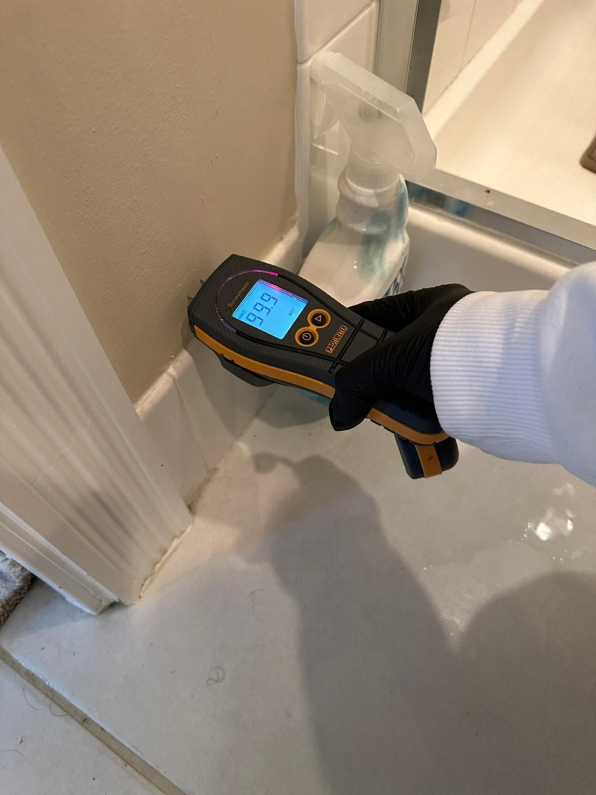 A person is using a thermometer to measure the humidity in a bathroom.