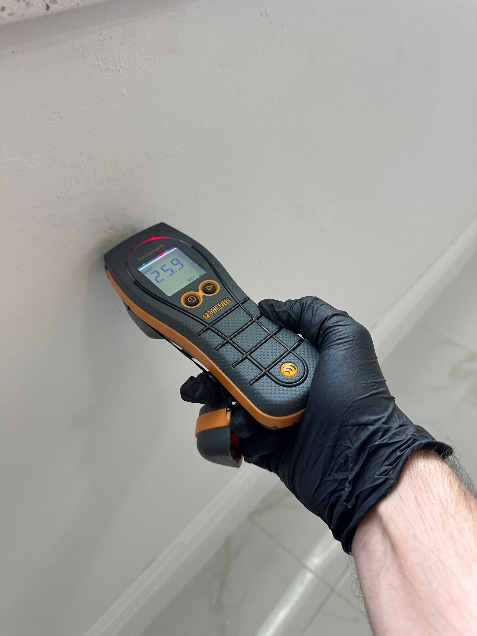 A person wearing black gloves is holding a cell phone in their hand.