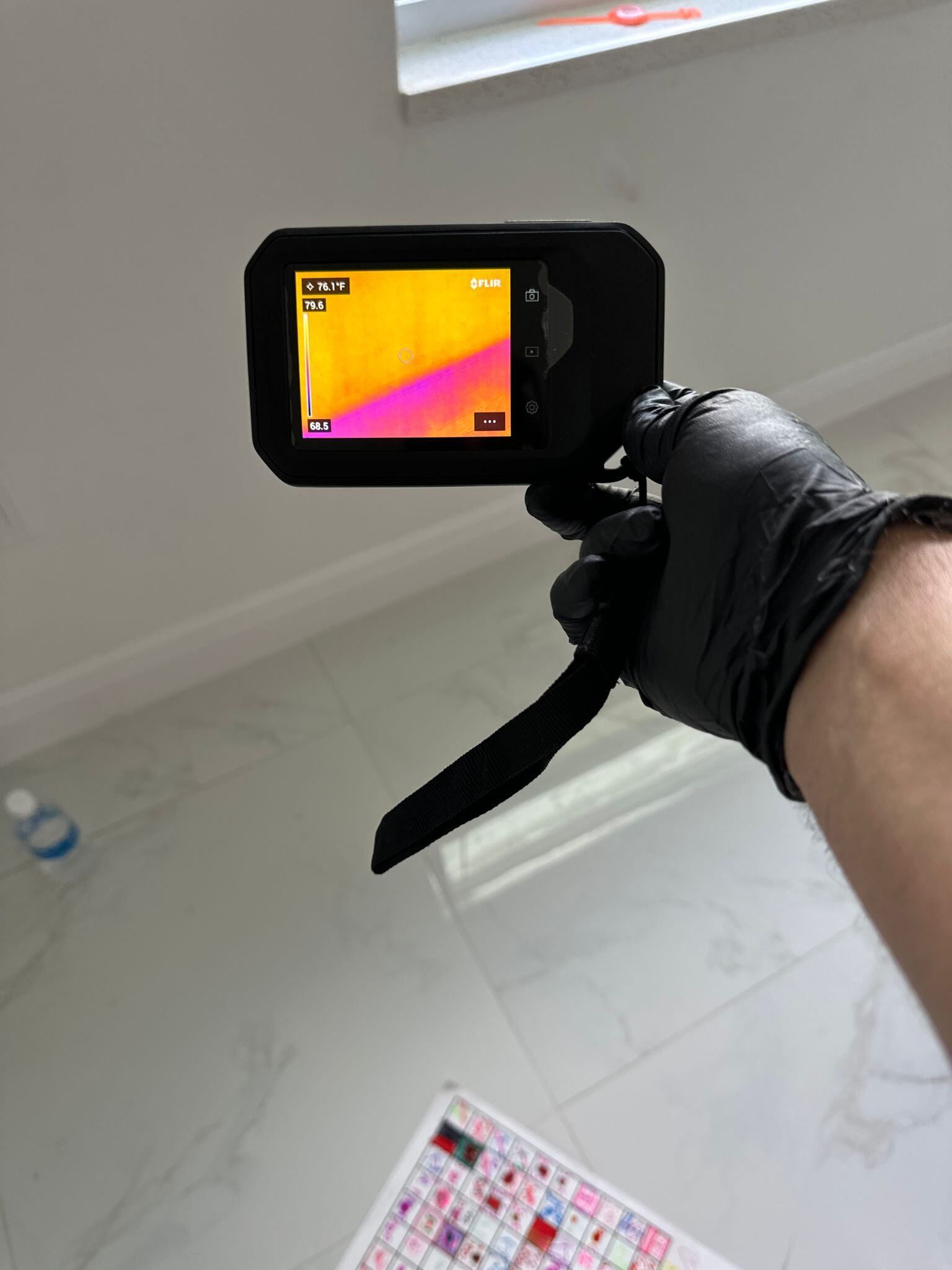 A person is holding a thermal camera in their hand.
