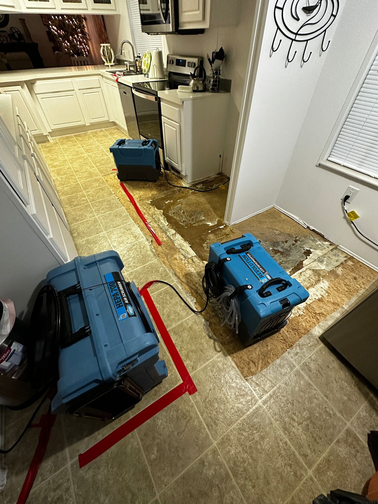 A kitchen with a lot of water coming out of the floor.