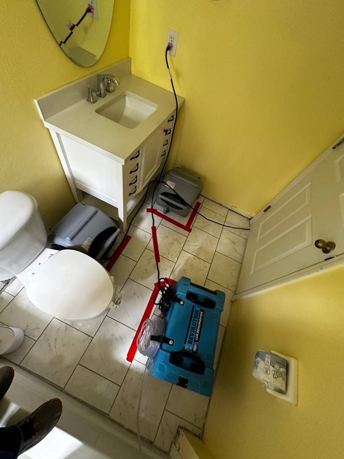 A bathroom with a toilet a sink and a mirror