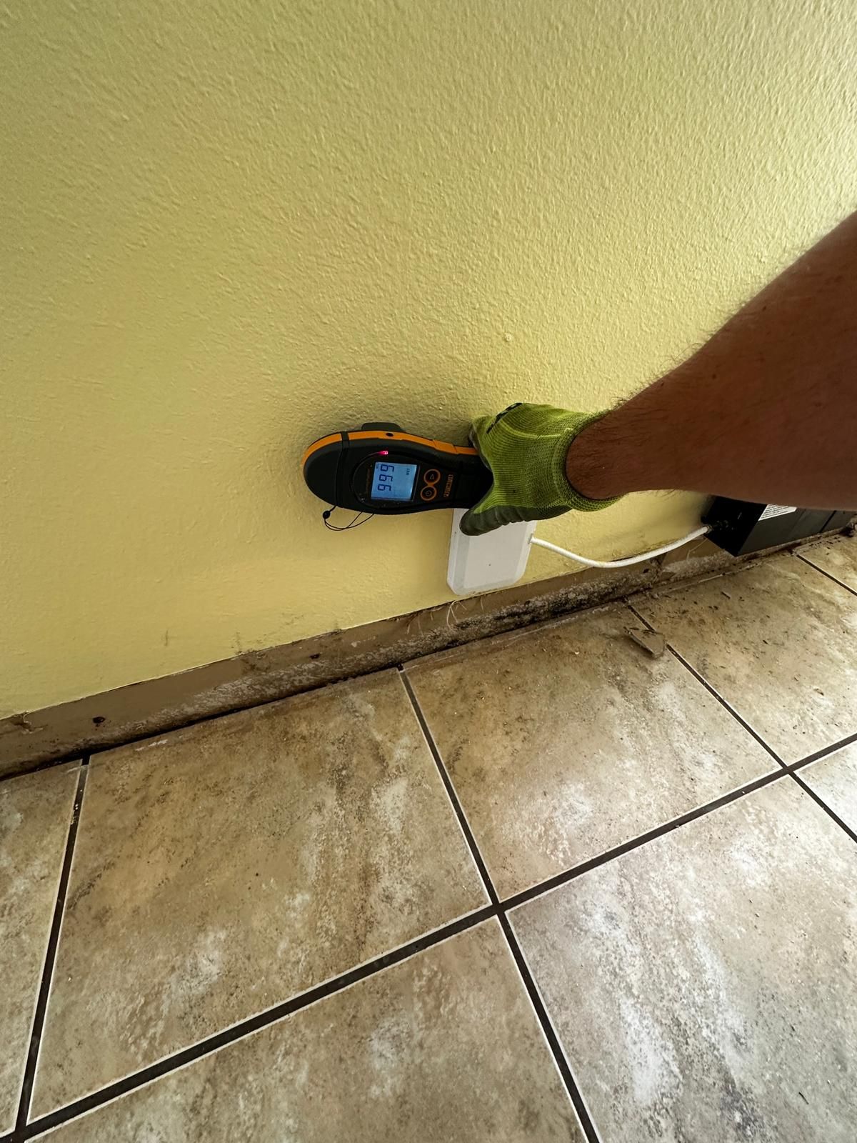 A person is measuring a wall with a tape measure.