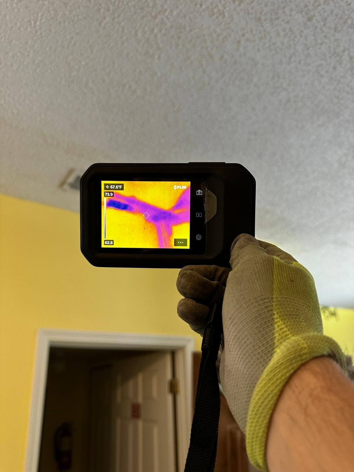 A person is holding a thermal camera in their hand.