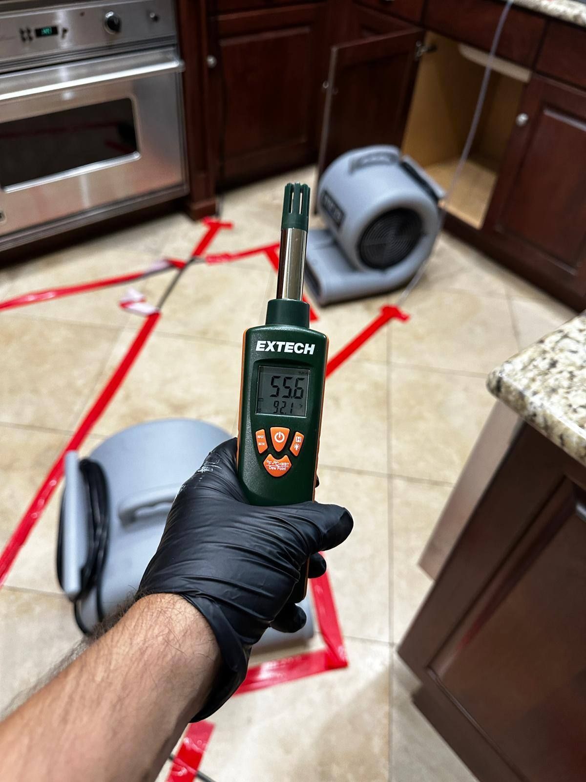 A person is holding a thermometer in a kitchen.