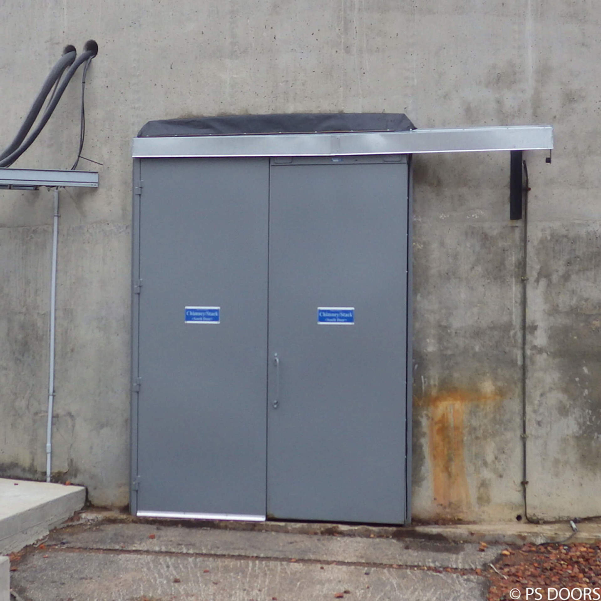 A gray sliding door on a concrete wall