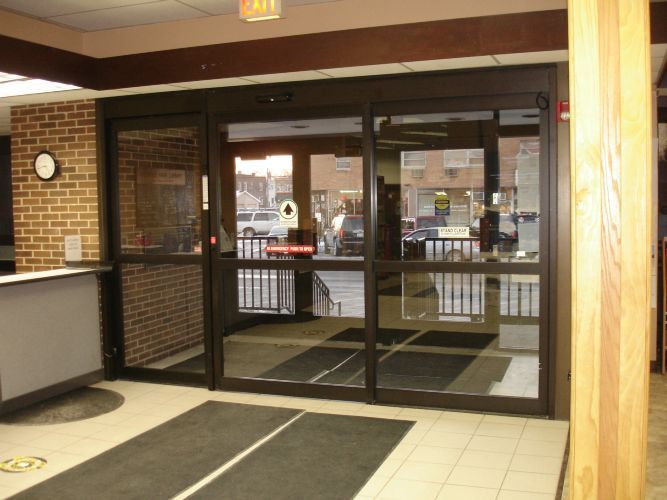 A lobby with a brick wall and sliding glass doors