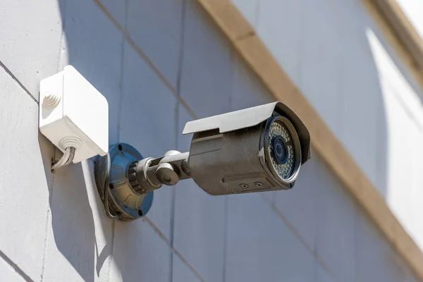 A security camera is mounted on the side of a building.