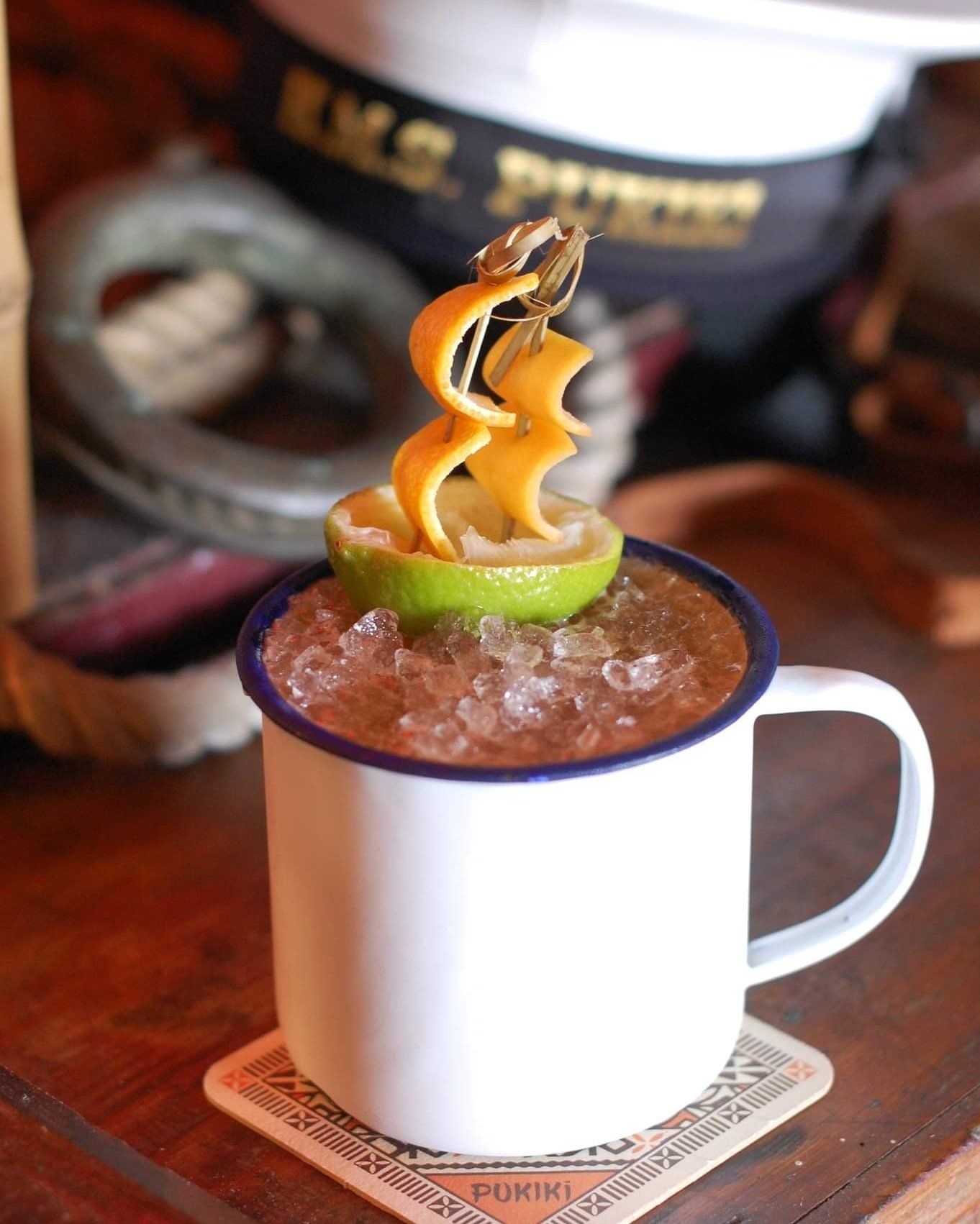 Classic Navy Grog cocktail with sailing ship garnish served in a tin mug