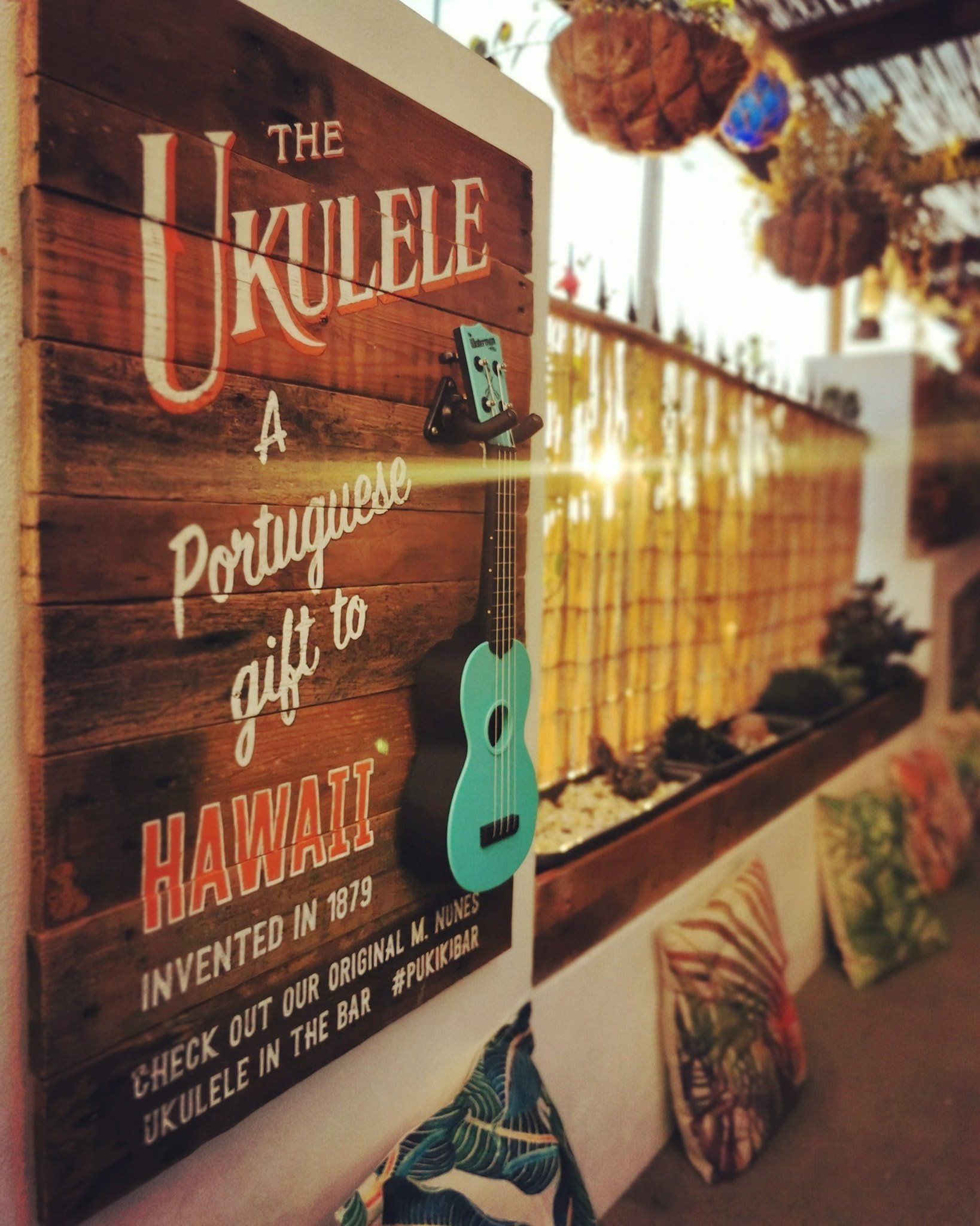 Sunset downstairs at Pukiki with a handpainted ukulele sign and seating