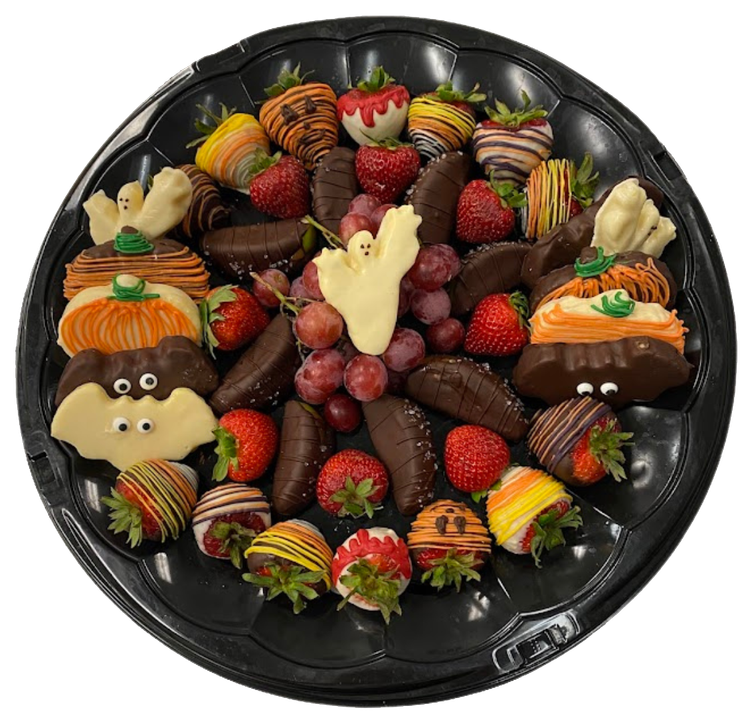 A skull shaped vase filled with strawberries and grapes