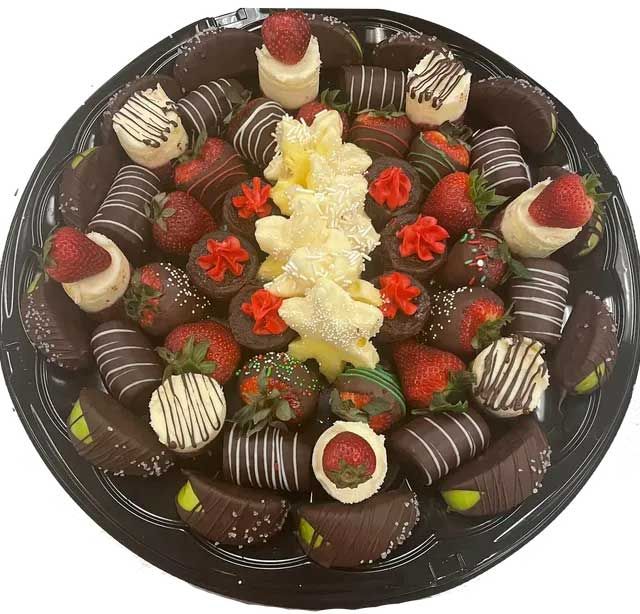 A black plate topped with chocolate covered strawberries.