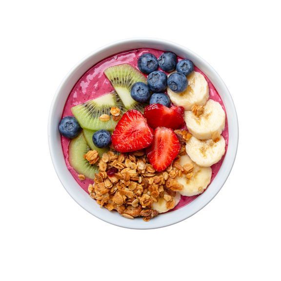 A bowl of fruit and granola on a white background