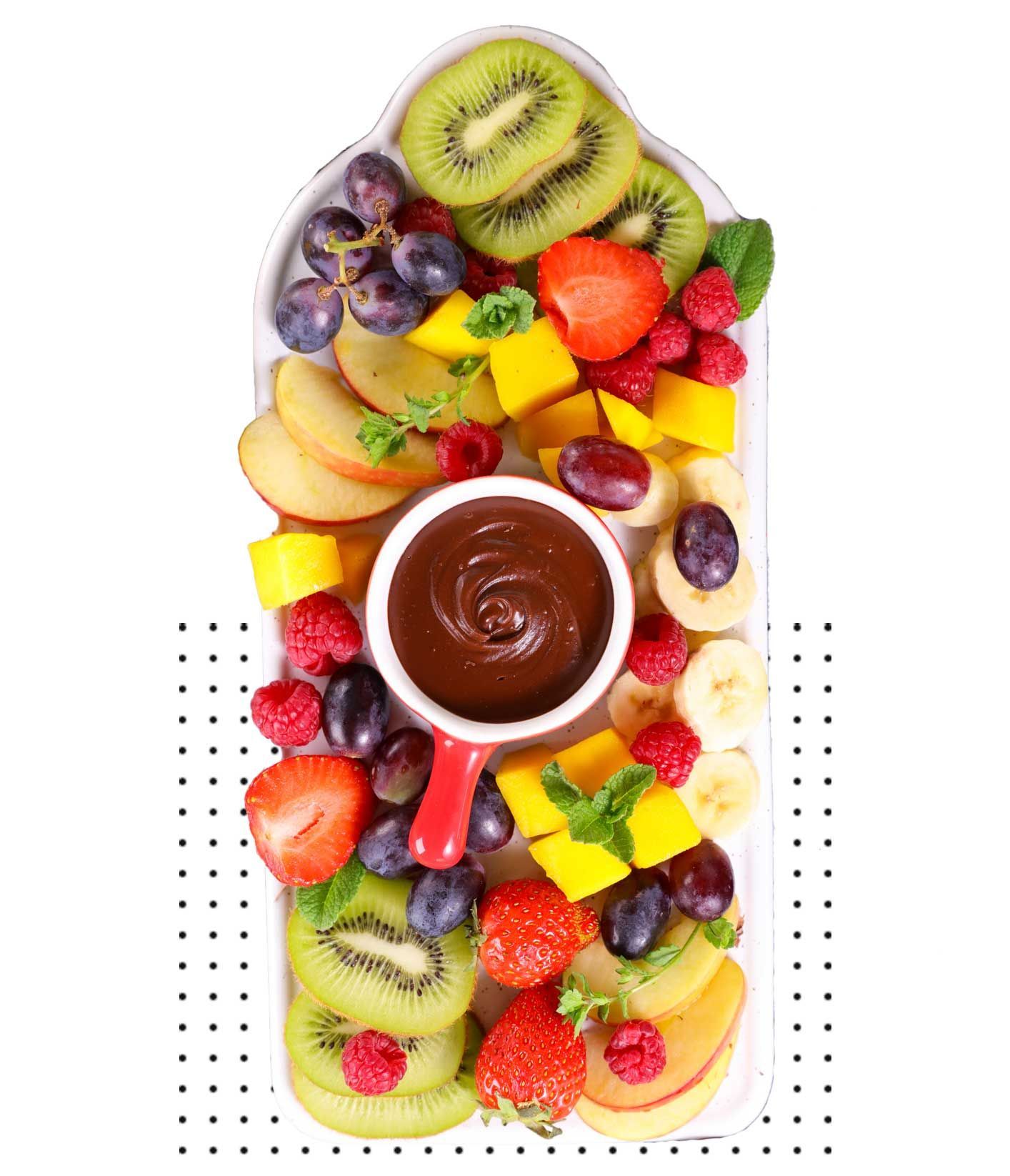 A white plate topped with sliced fruit and a cup of chocolate sauce.