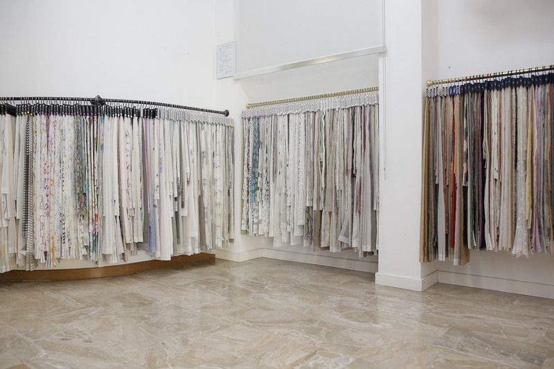 Fabric samples displayed on racks in a well-lit showroom.