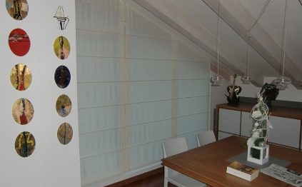 Interior with a dining table, artwork, sheer window shades, and a sideboard.