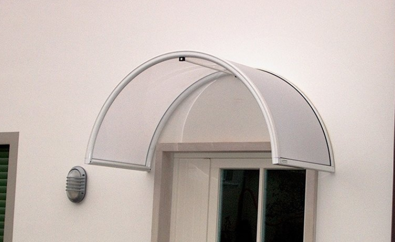 Arched, translucent awning over a white doorway, mounted on a white wall.