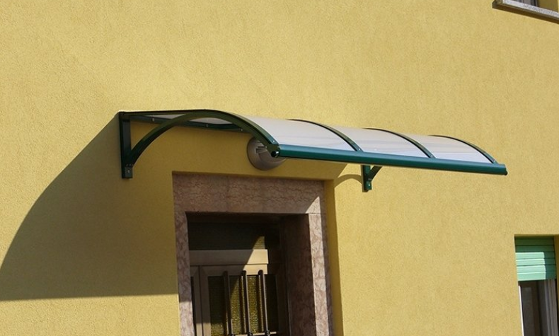 Green-framed awning above a doorway on a yellow building.
