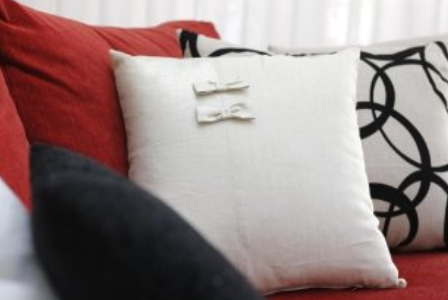 Red couch with white and black patterned pillows.