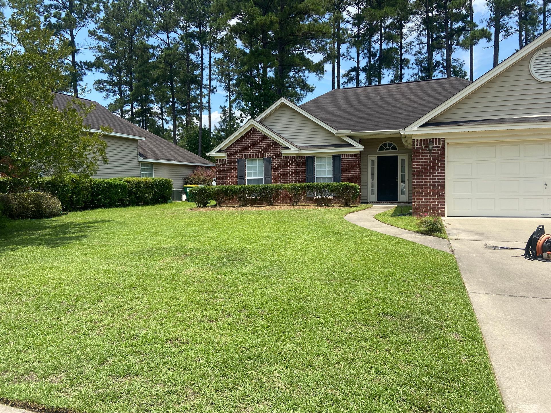 A brick house with a lush green lawn in front of it.