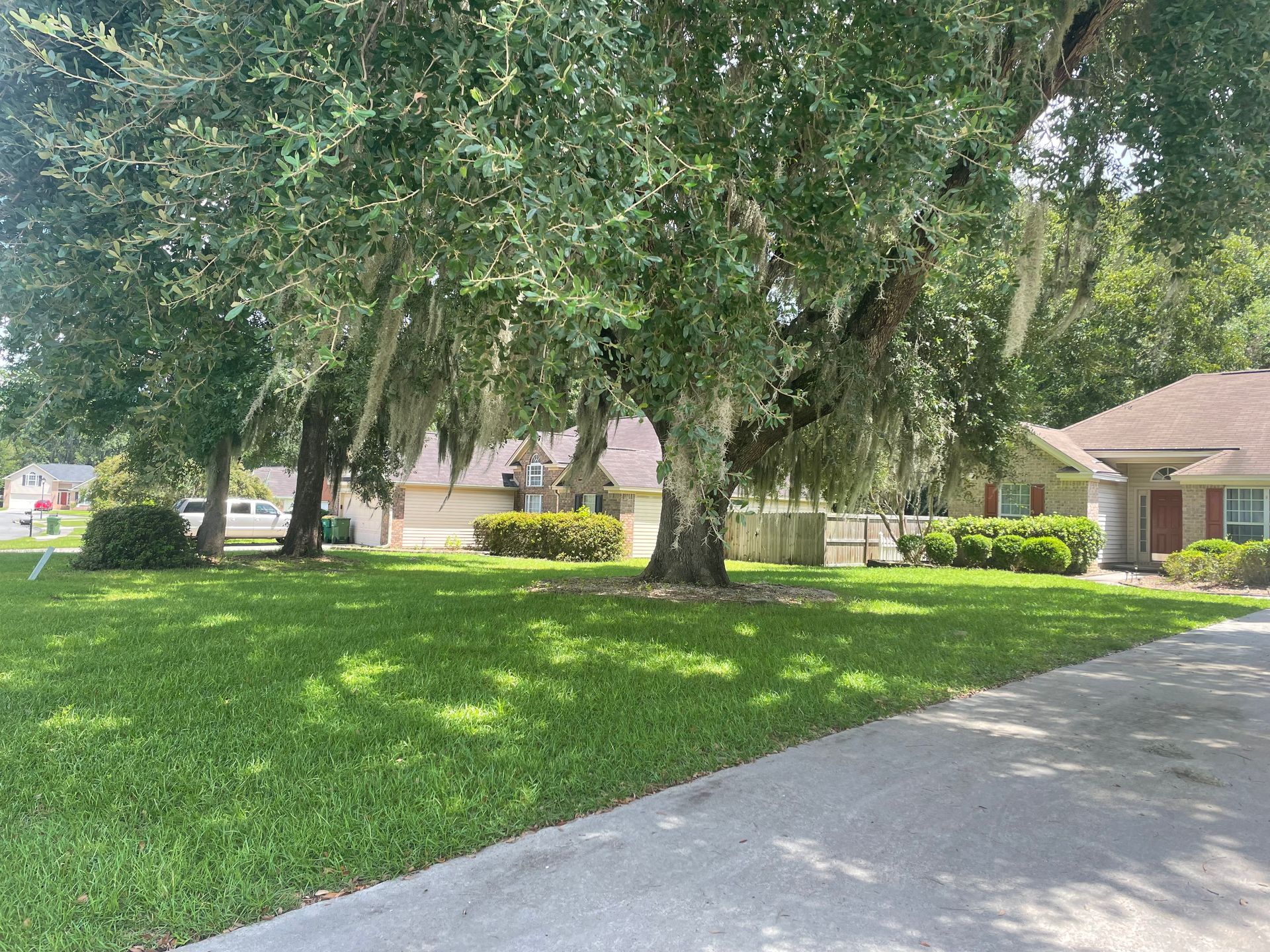 A house with a lot of grass and trees in front of it