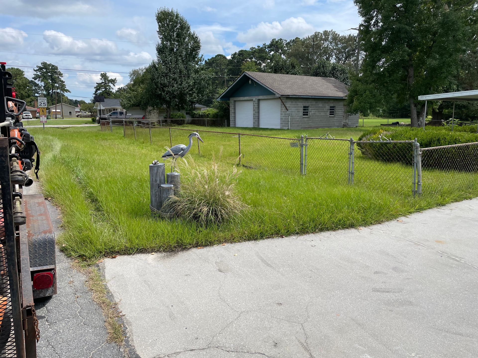 A truck is parked on the side of the road next to a grassy field.