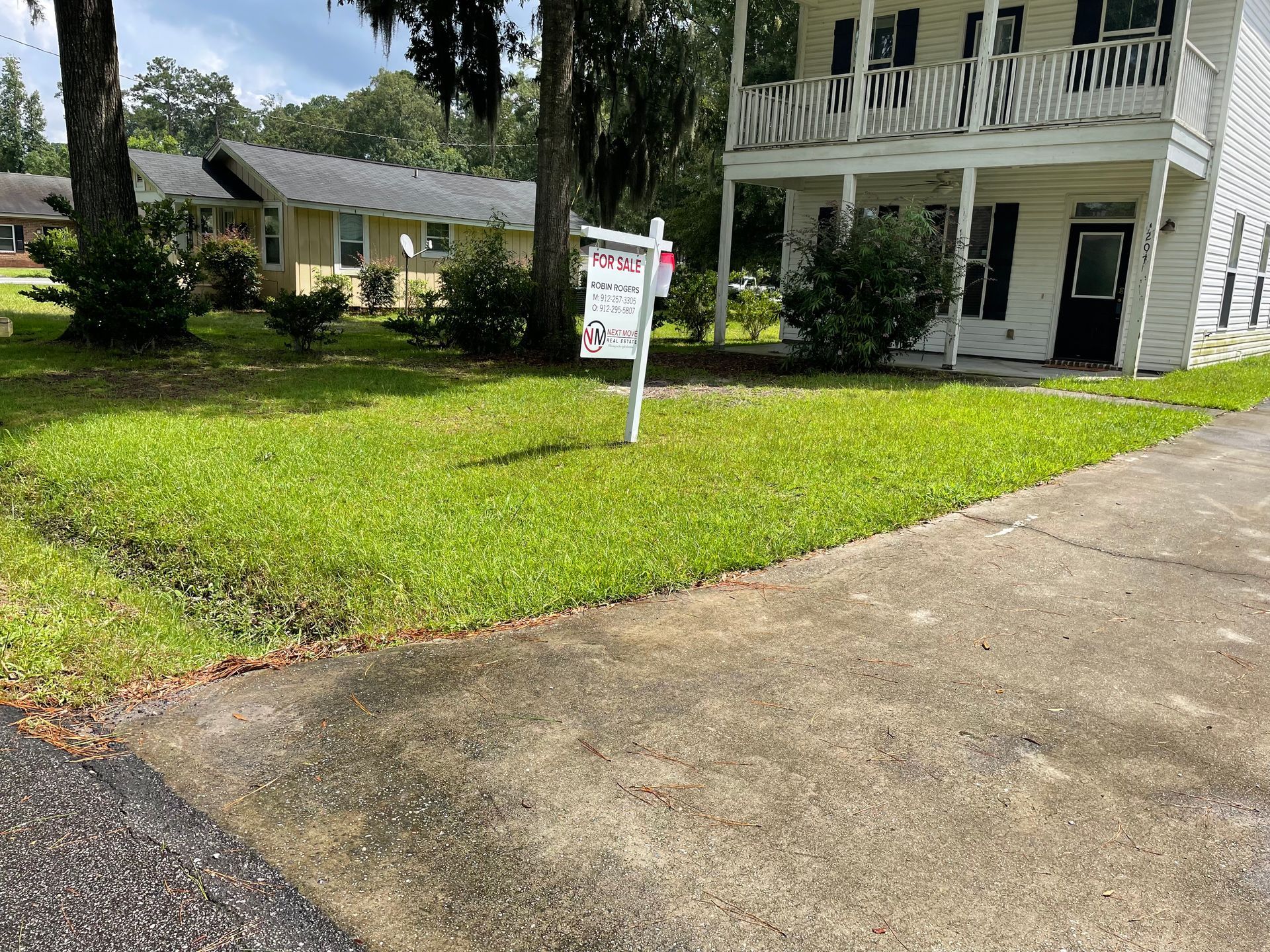 A house with a for sale sign in front of it.