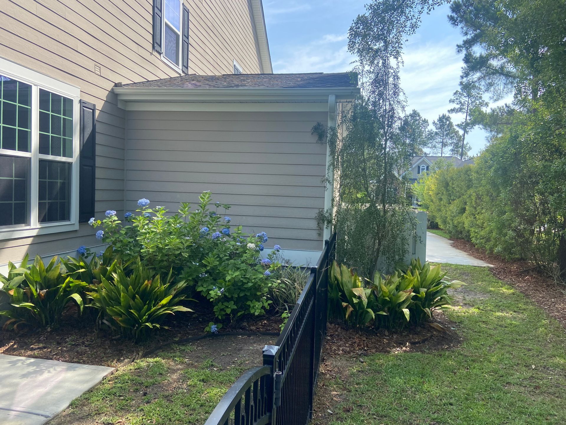 A house with a fence in front of it and a walkway leading to it.