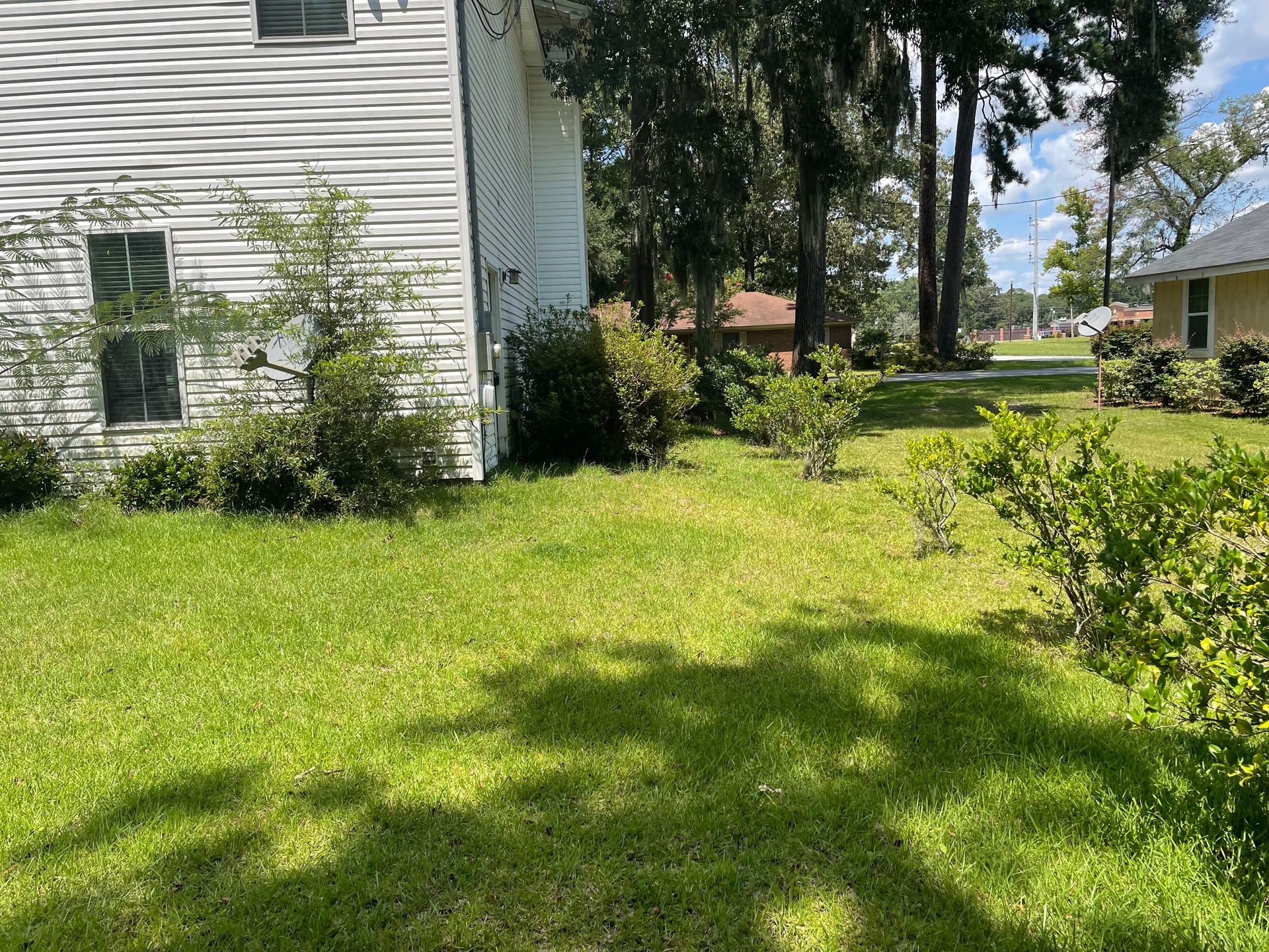 A white house with a lot of grass in front of it.
