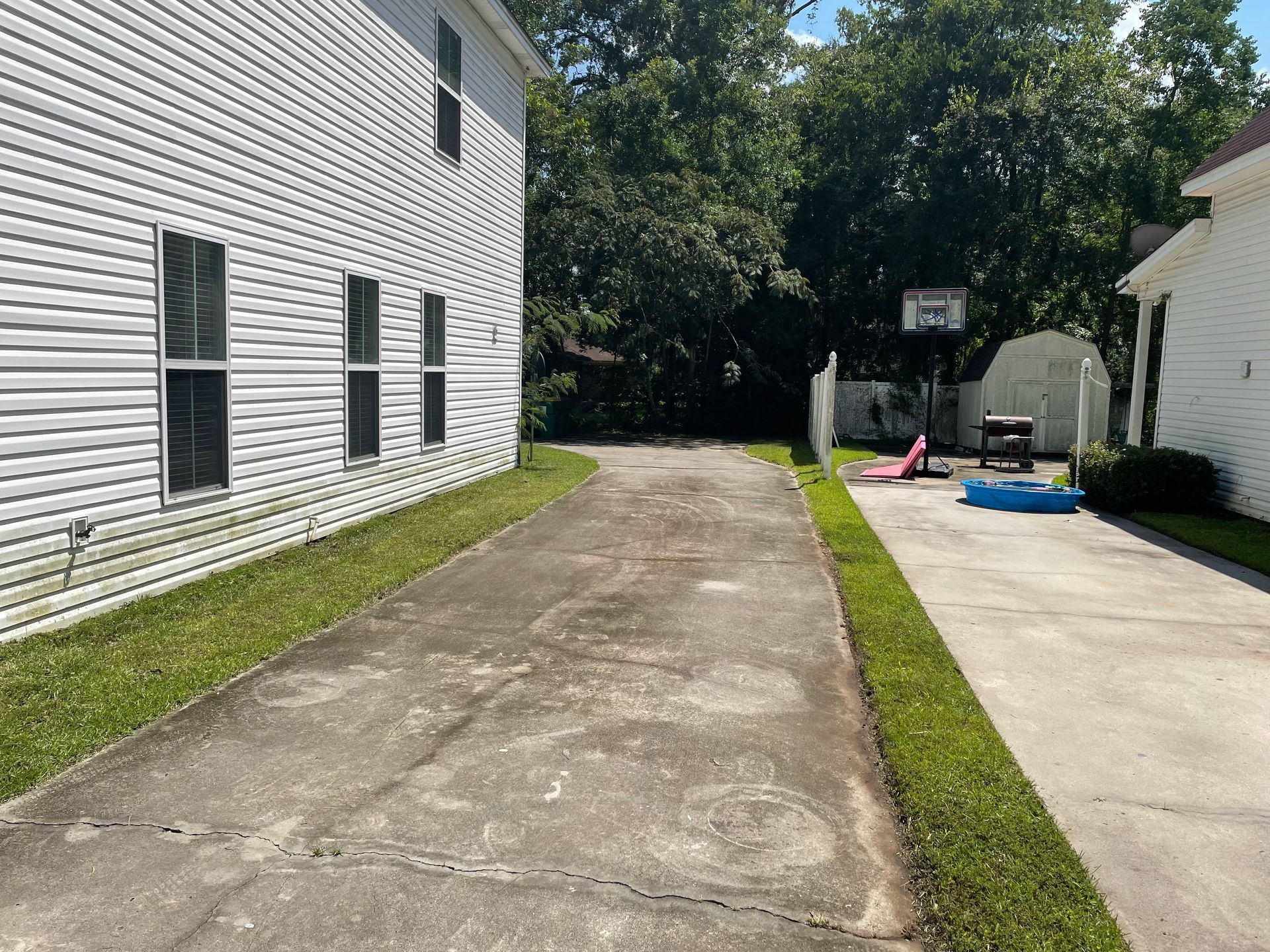 There is a basketball hoop in the backyard of a house.