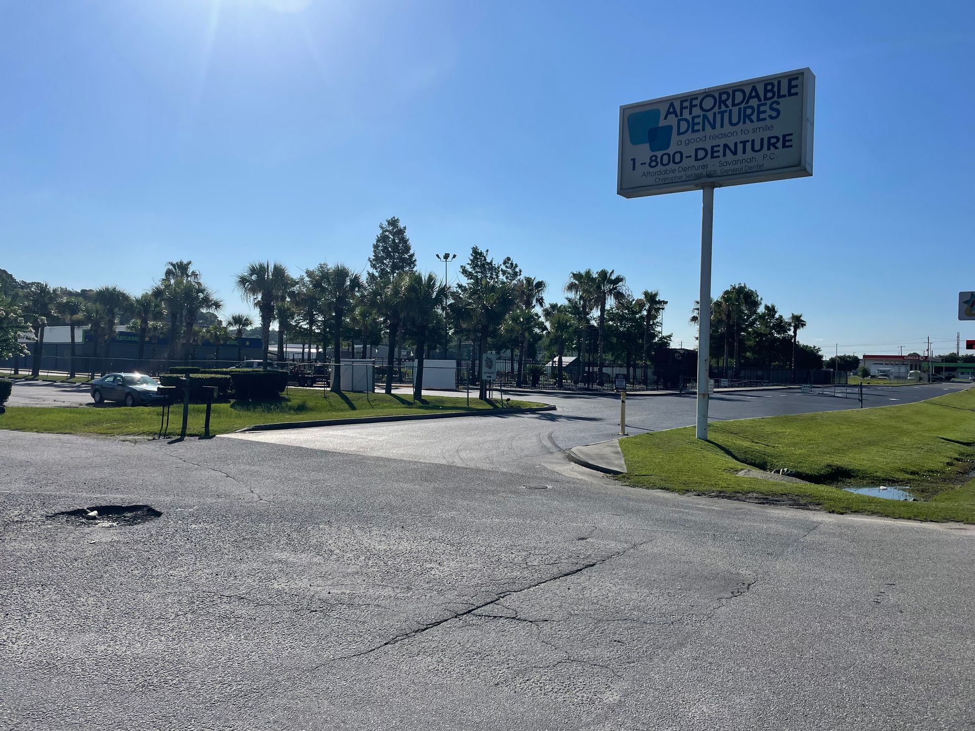 A sign for affordable dentures is sitting on the side of the road.