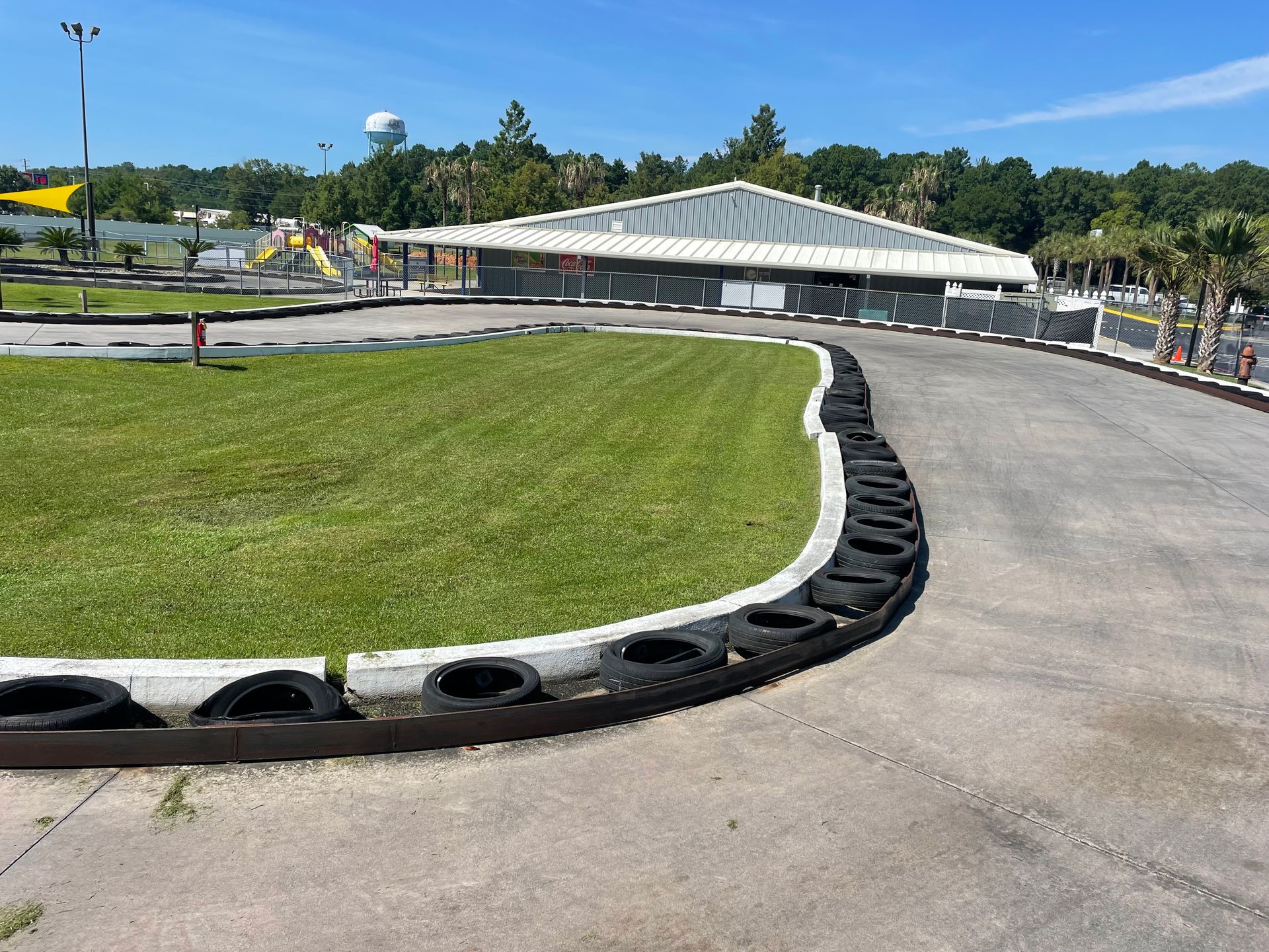 A race track with a lot of tires on it and a building in the background.