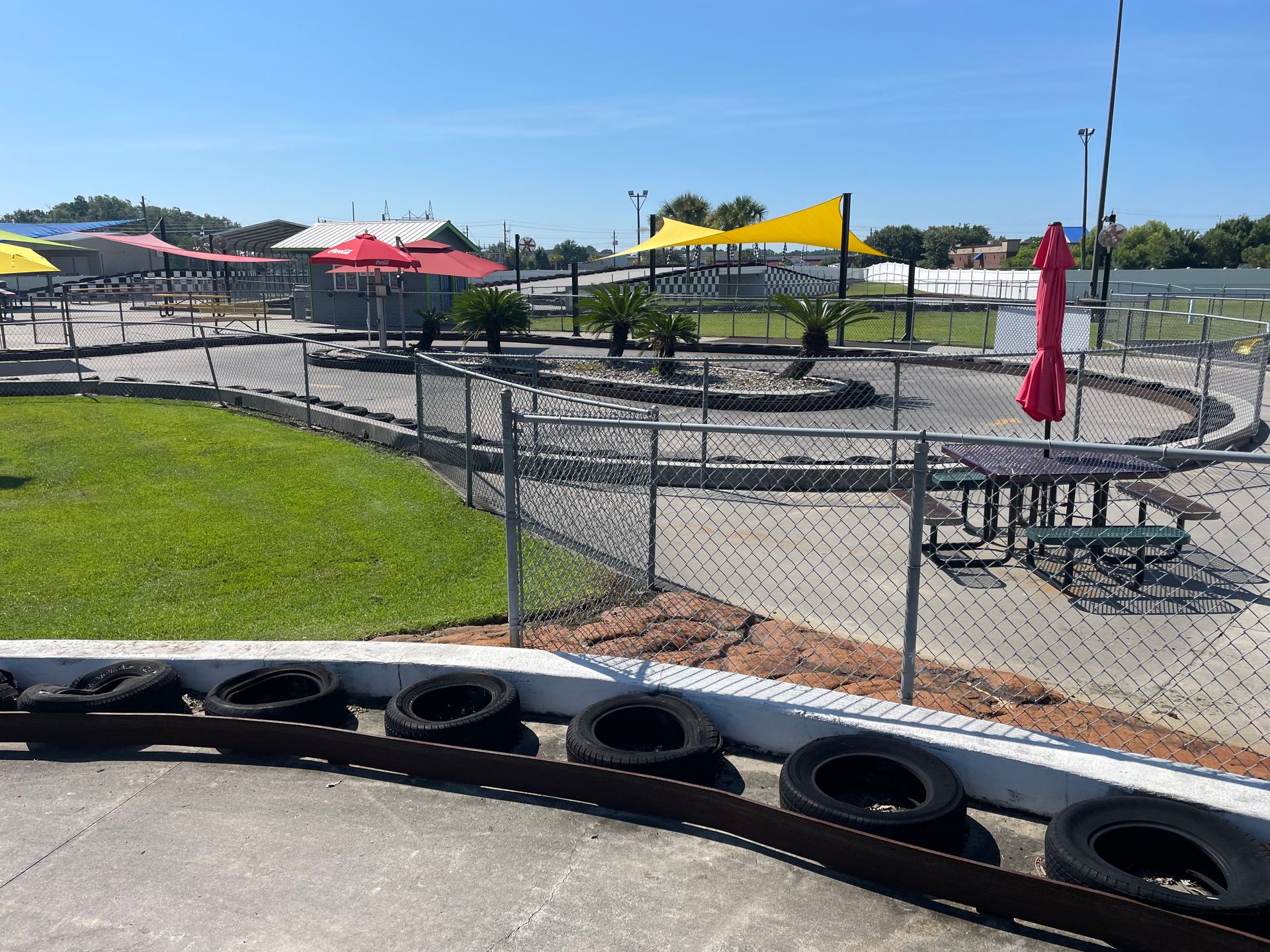 A go kart track with a chain link fence surrounding it.