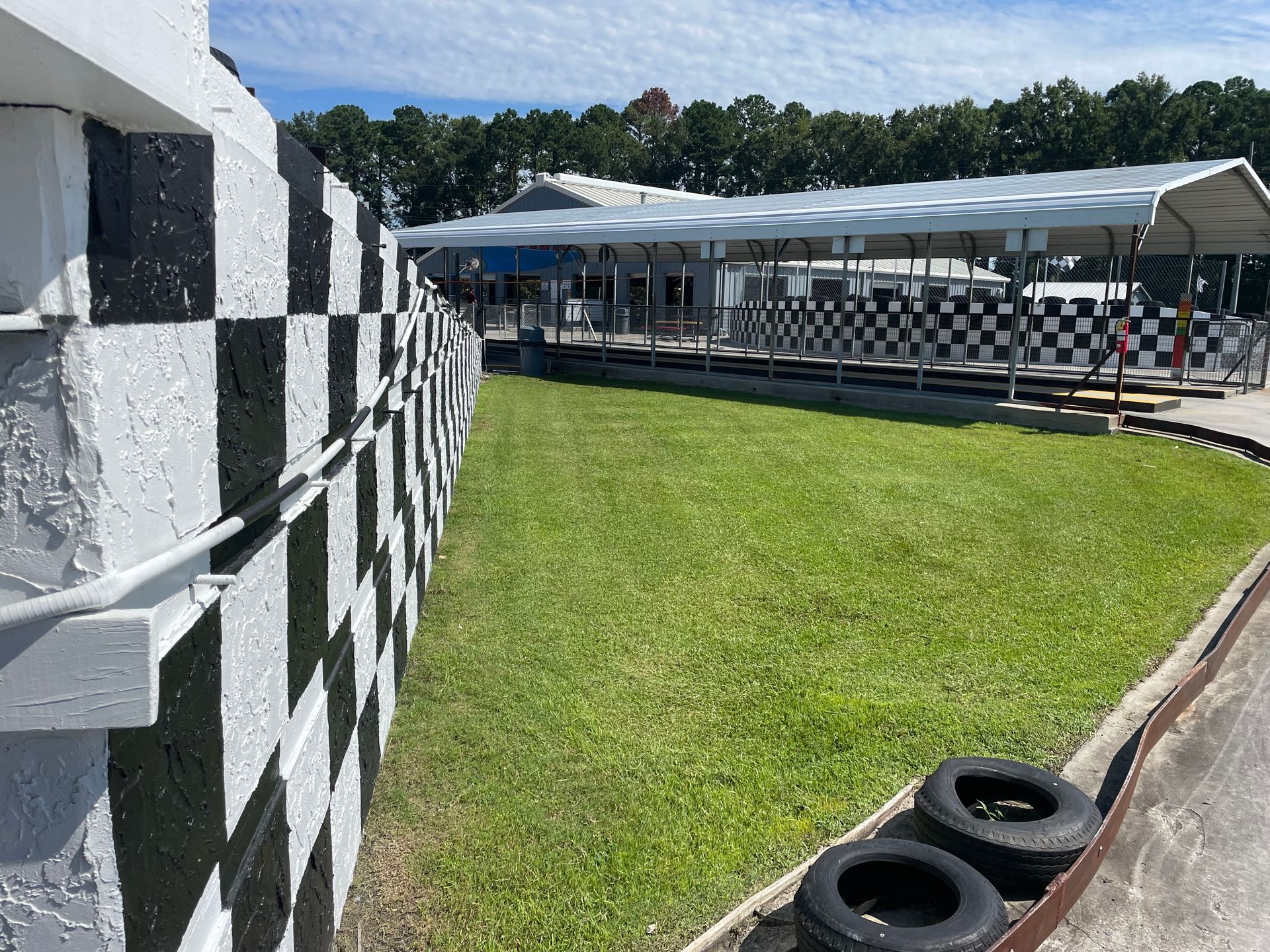A black and white checkered fence surrounds a race track.
