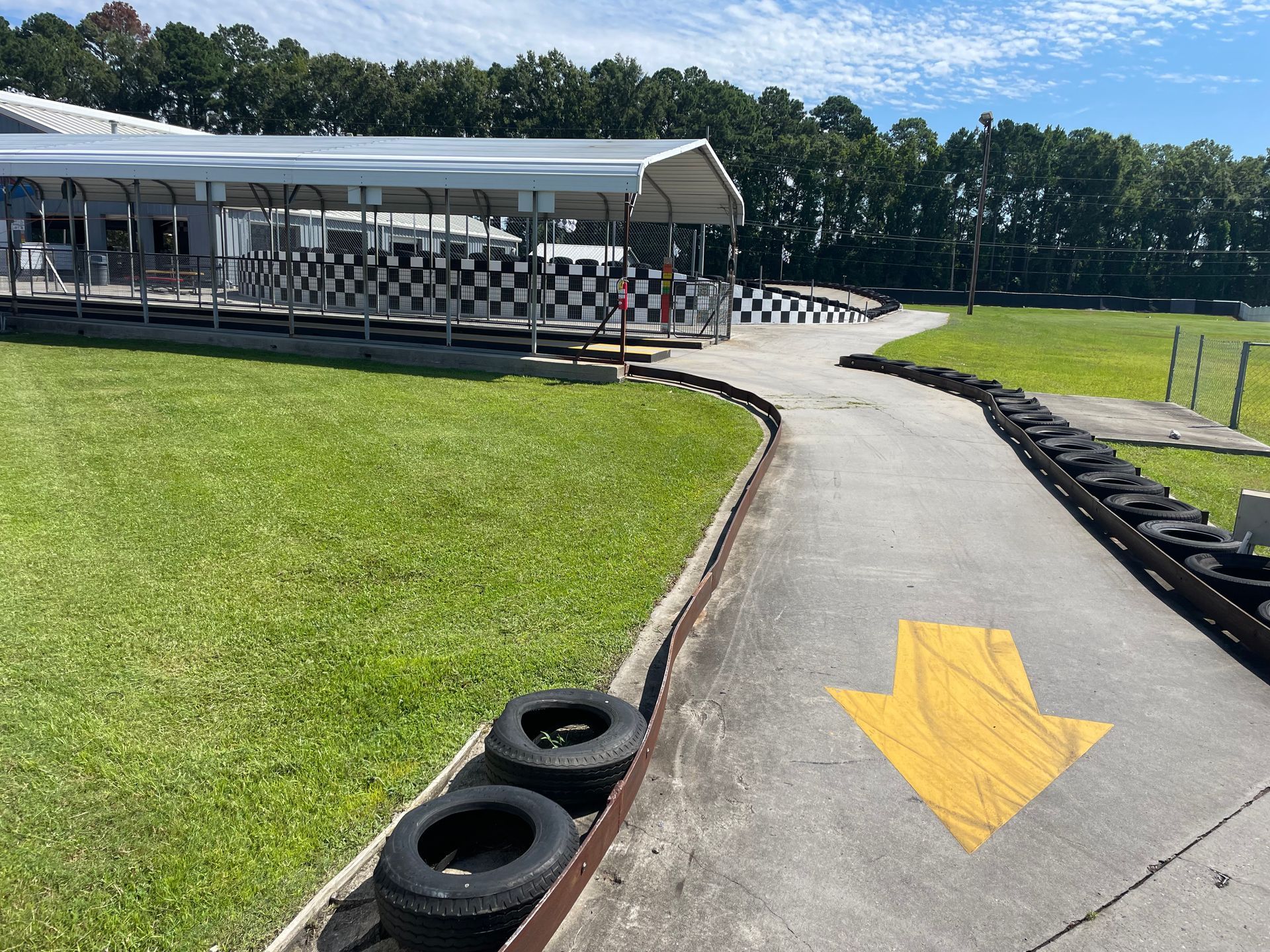 A go kart track with a yellow arrow pointing to the right.
