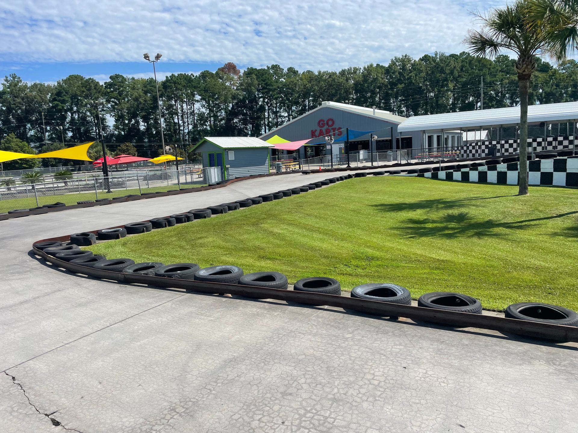 A race track with tires on the side of it and a building in the background.
