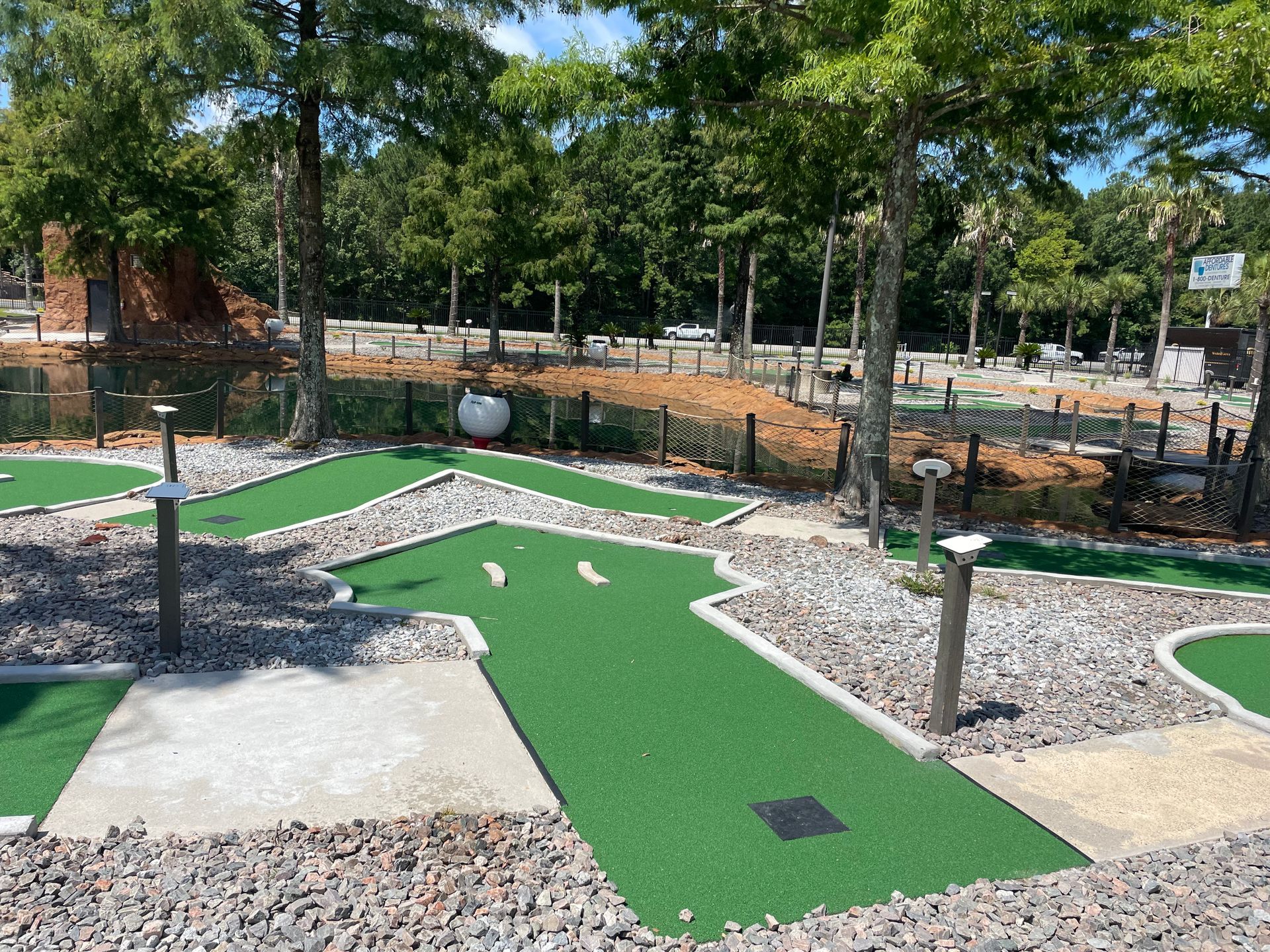 A small golf course in a park with trees in the background.