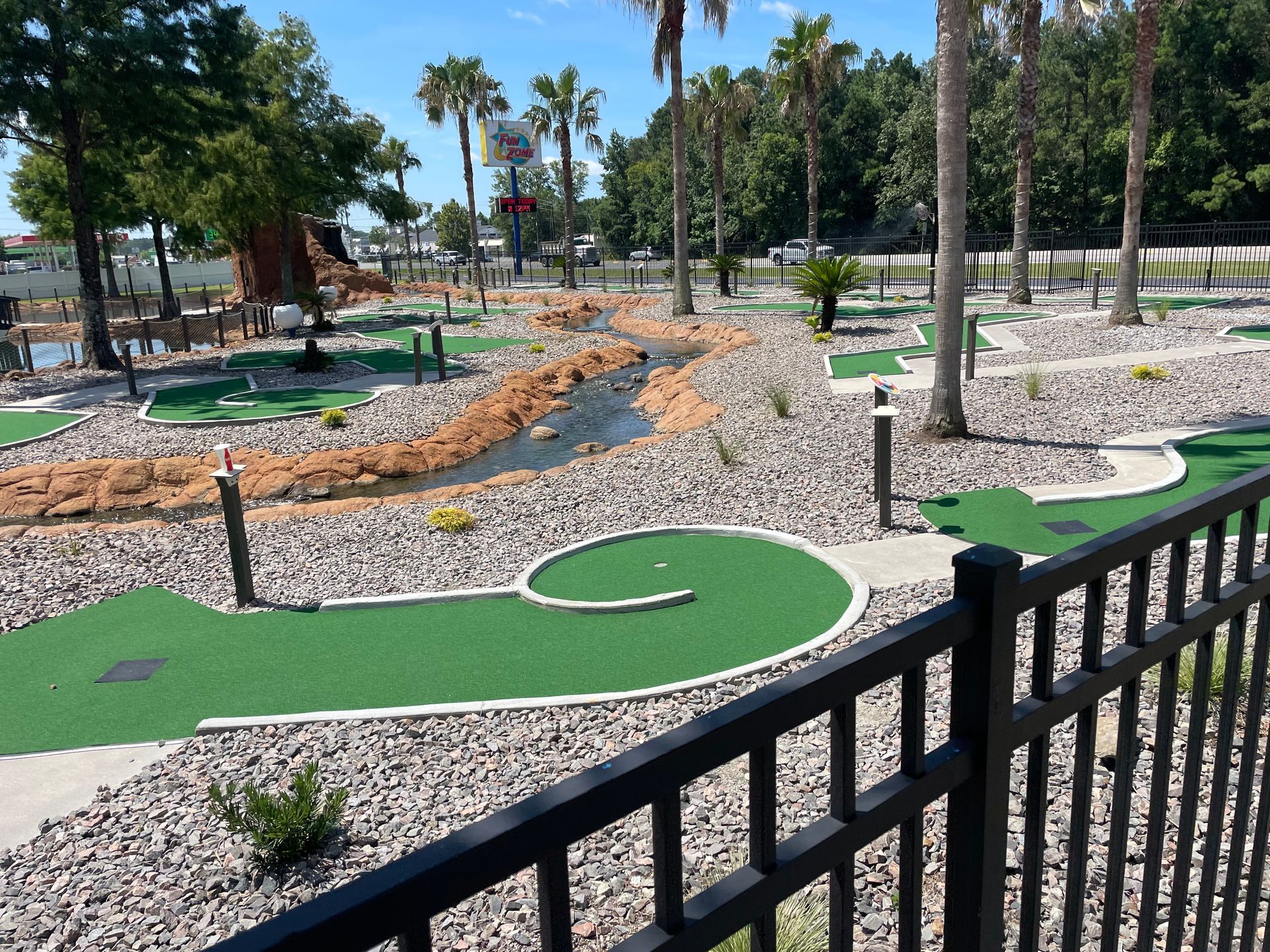 A view of a mini golf course from behind a fence