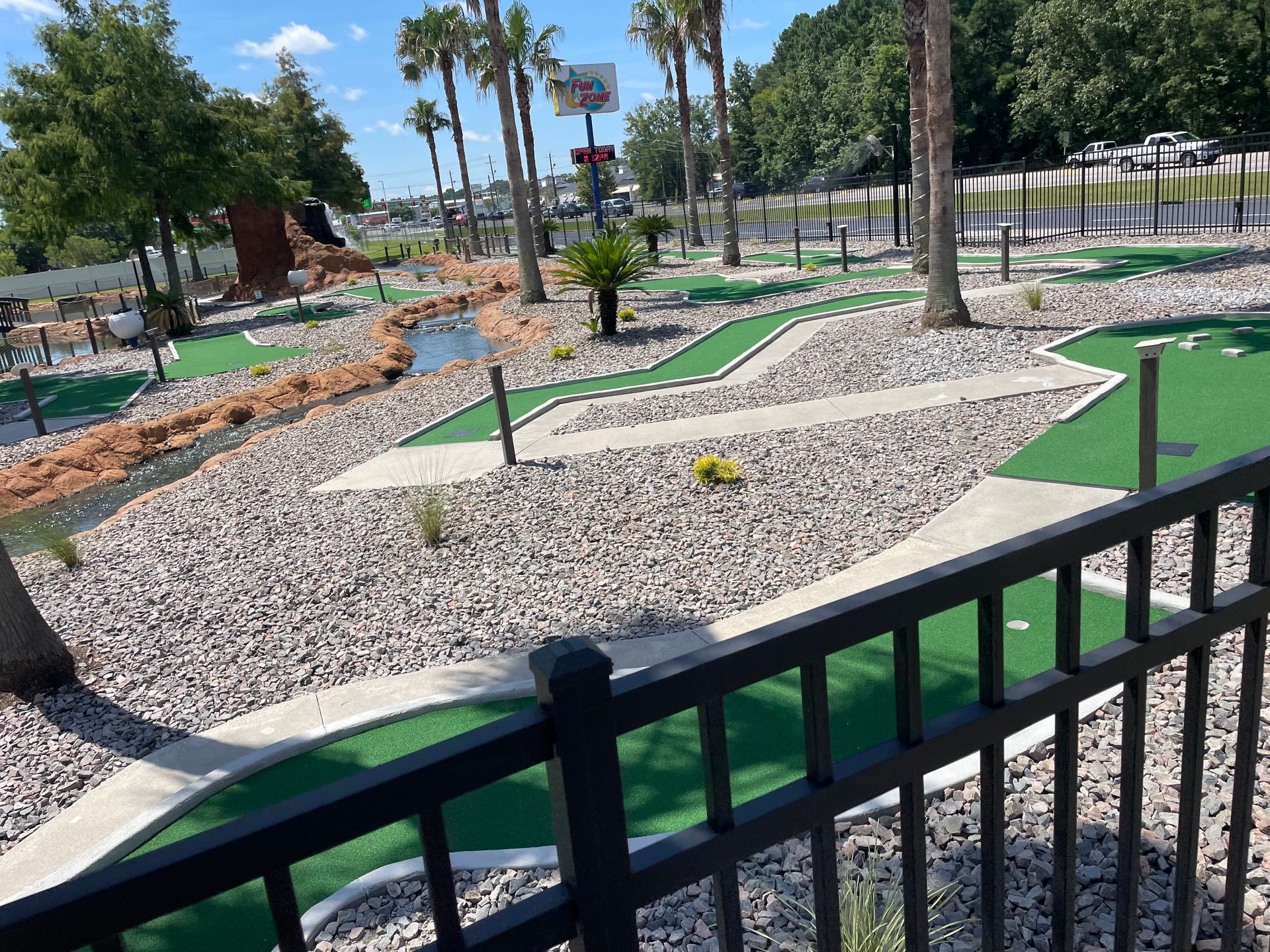 A view of a mini golf course from behind a fence.