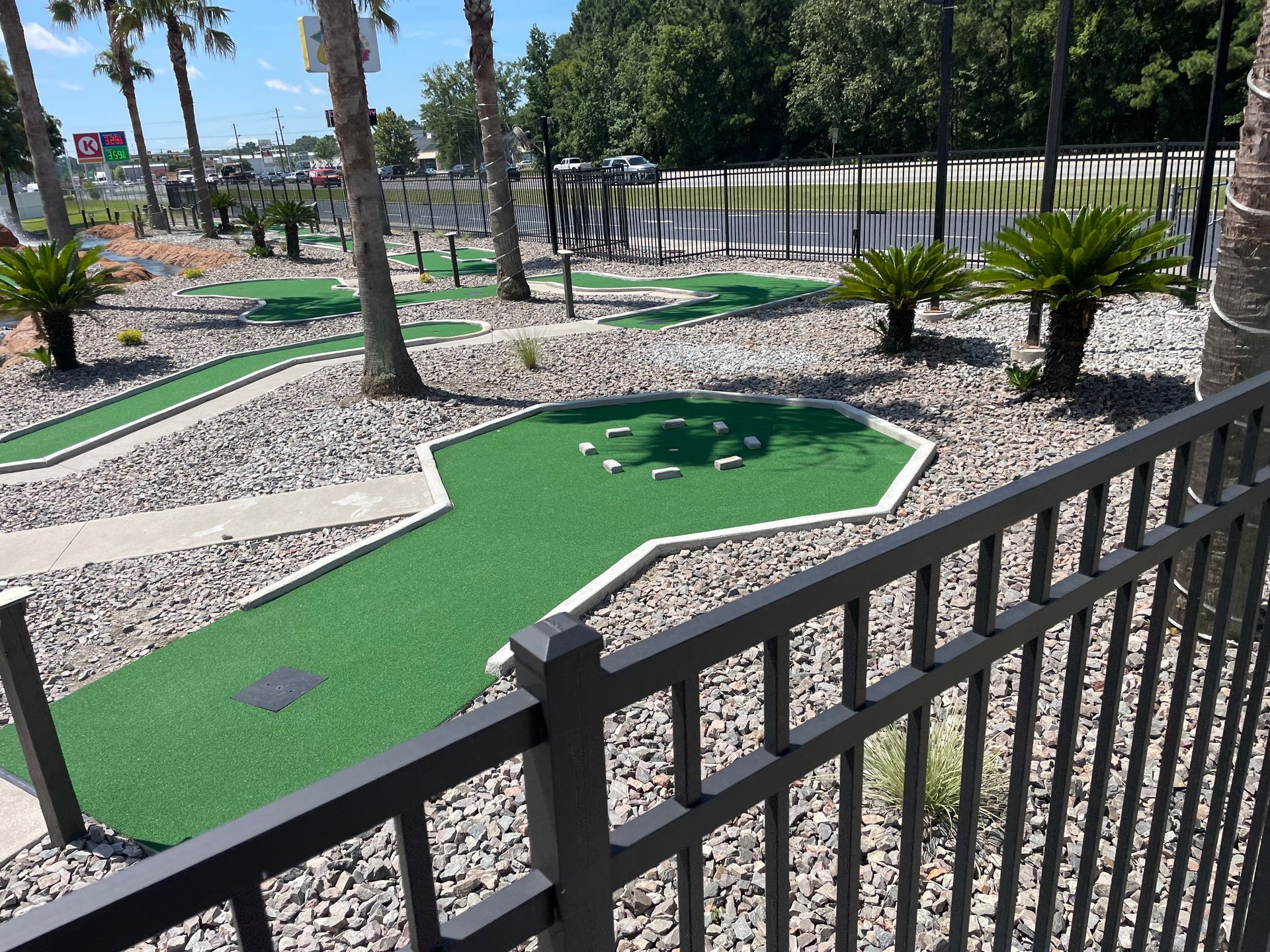 A view of a mini golf course from behind a fence