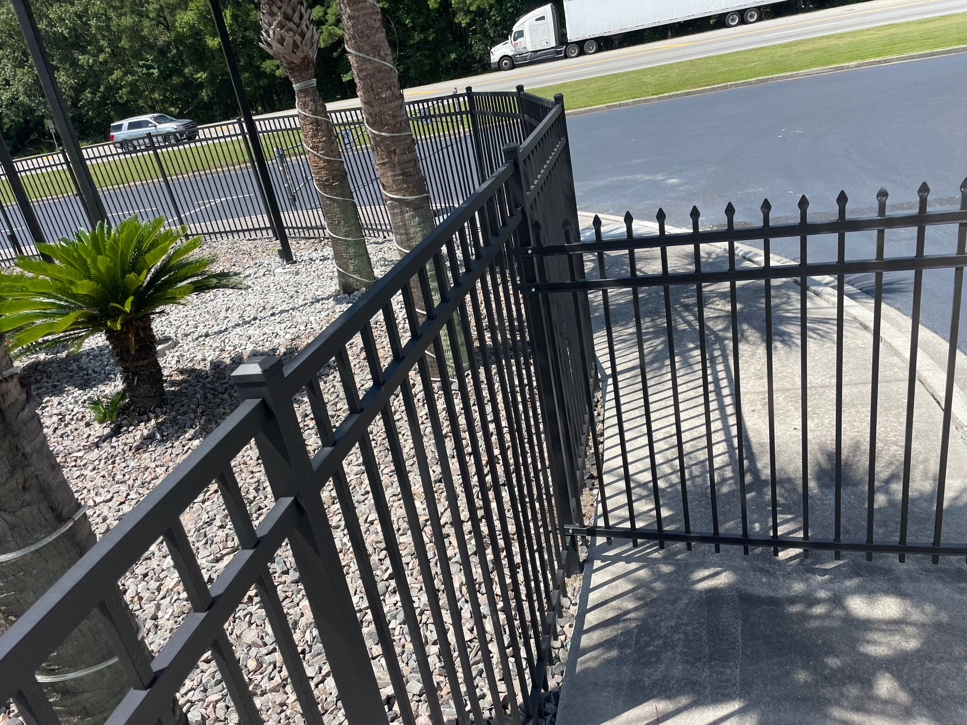 A black fence with a truck in the background