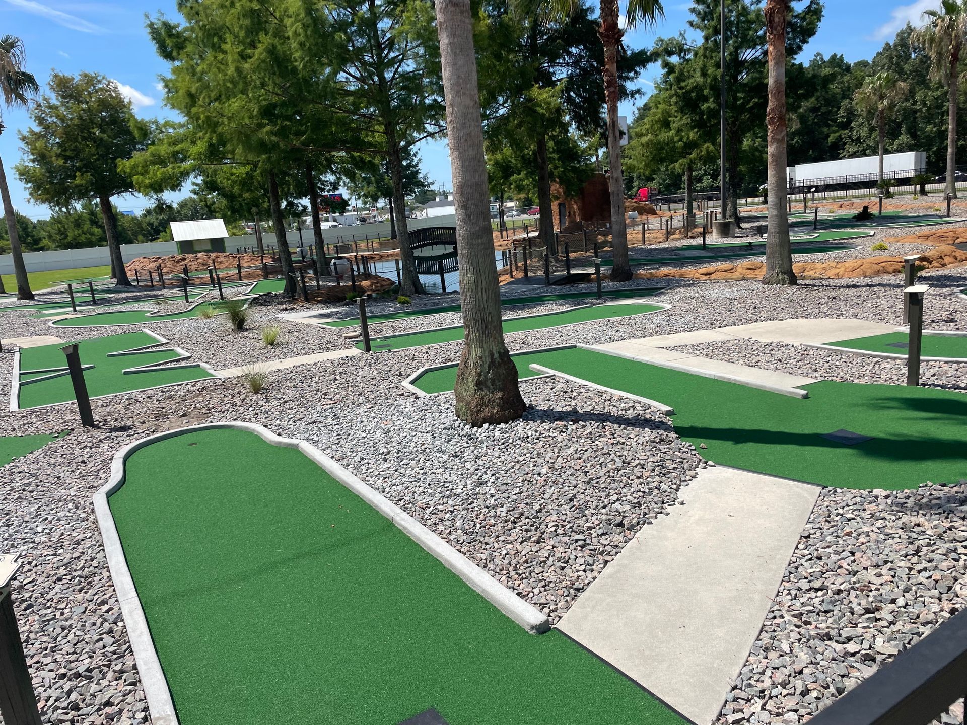 A mini golf course in a park with trees in the background