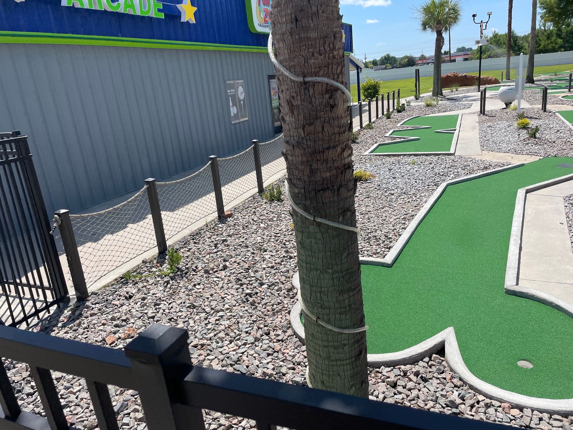 A view of a mini golf course from behind a fence.