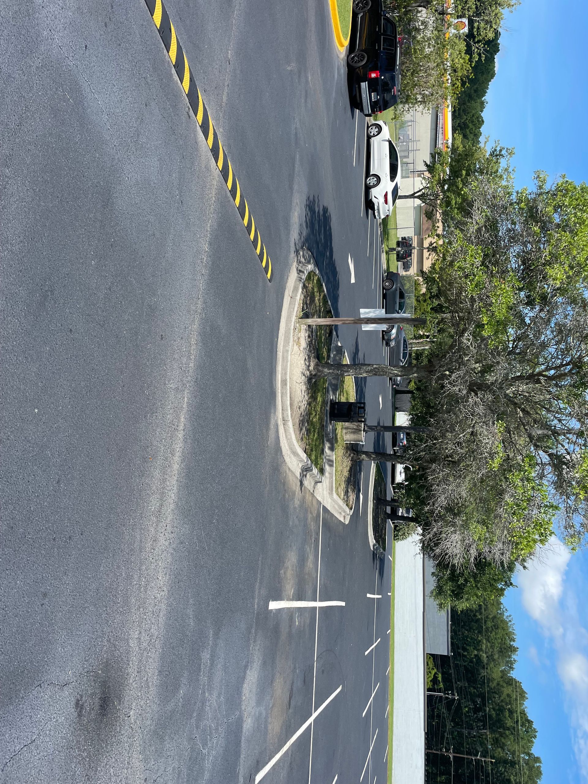 A car is parked on the side of the road next to a tree.