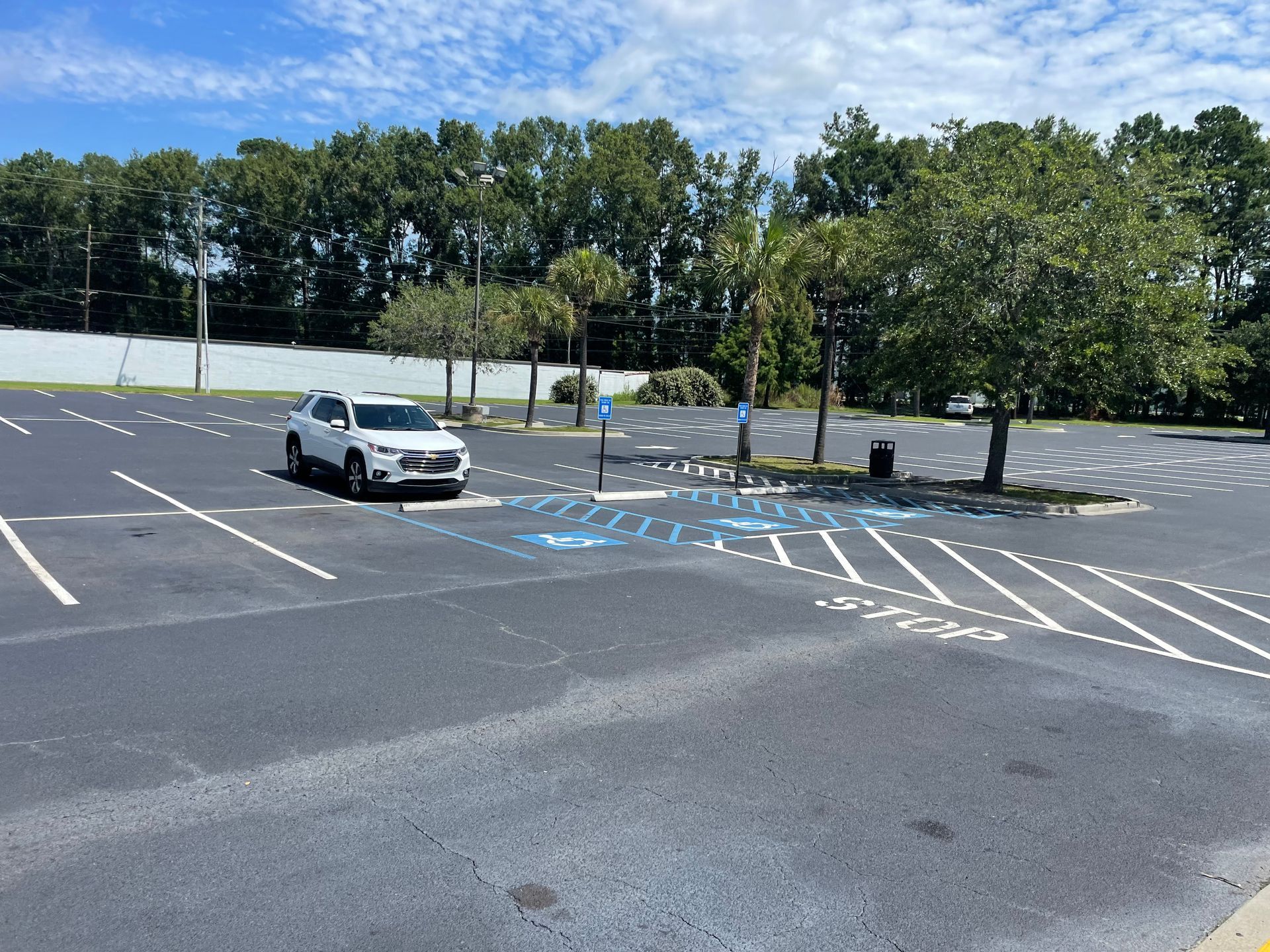 A white suv is parked in a handicapped parking spot