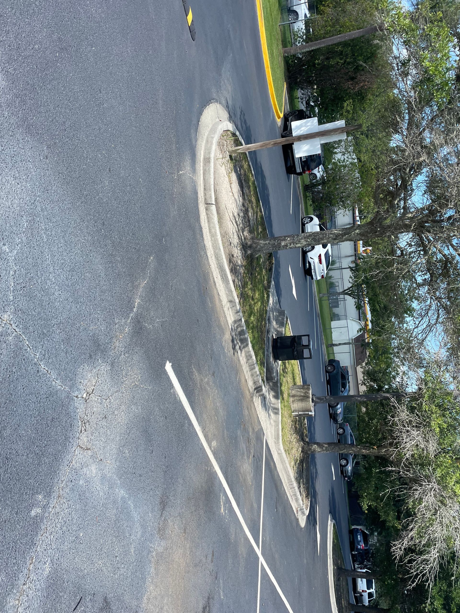 A car is driving down a street with trees on the side of it.