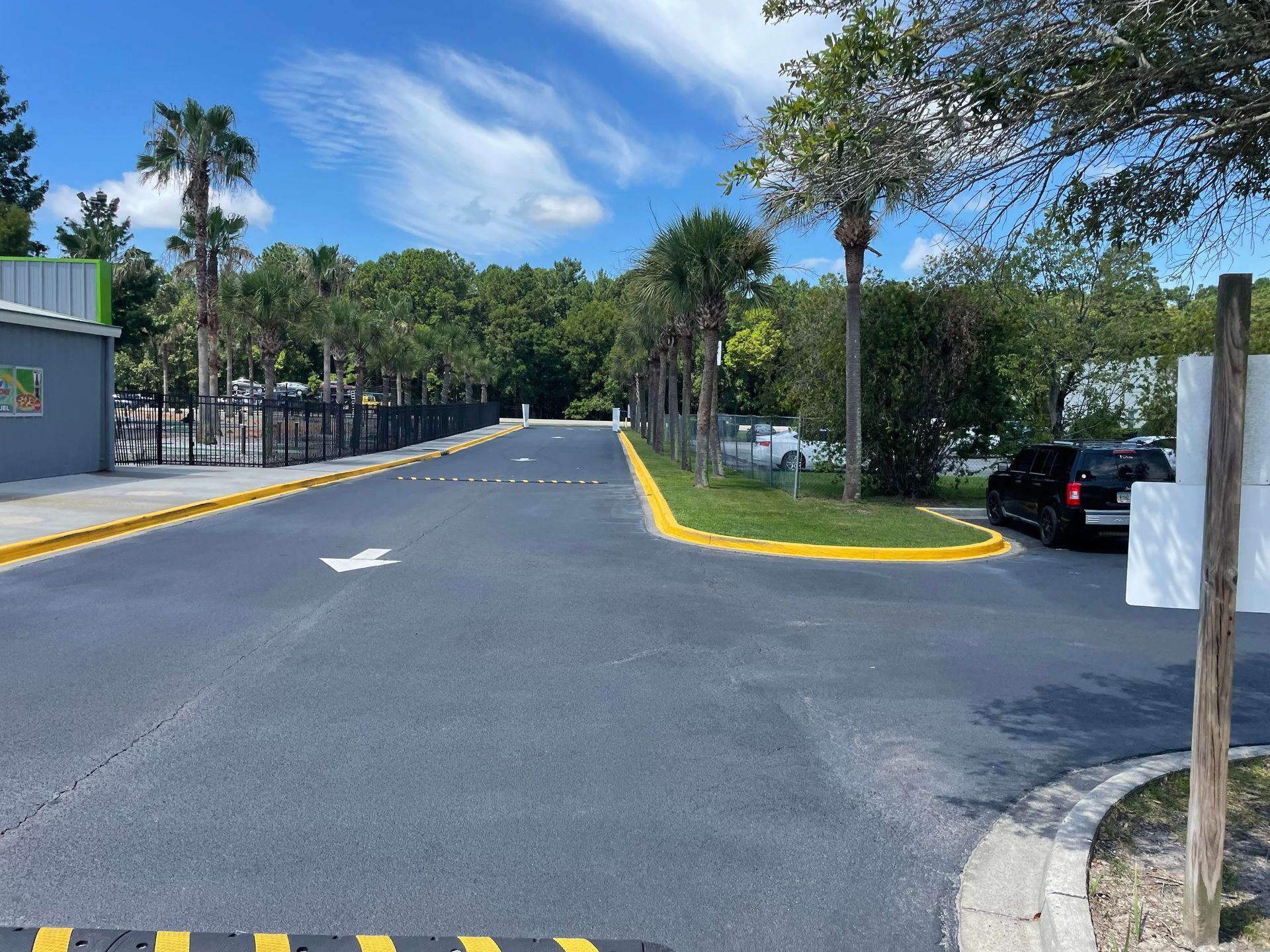 A black car is parked on the side of a road.