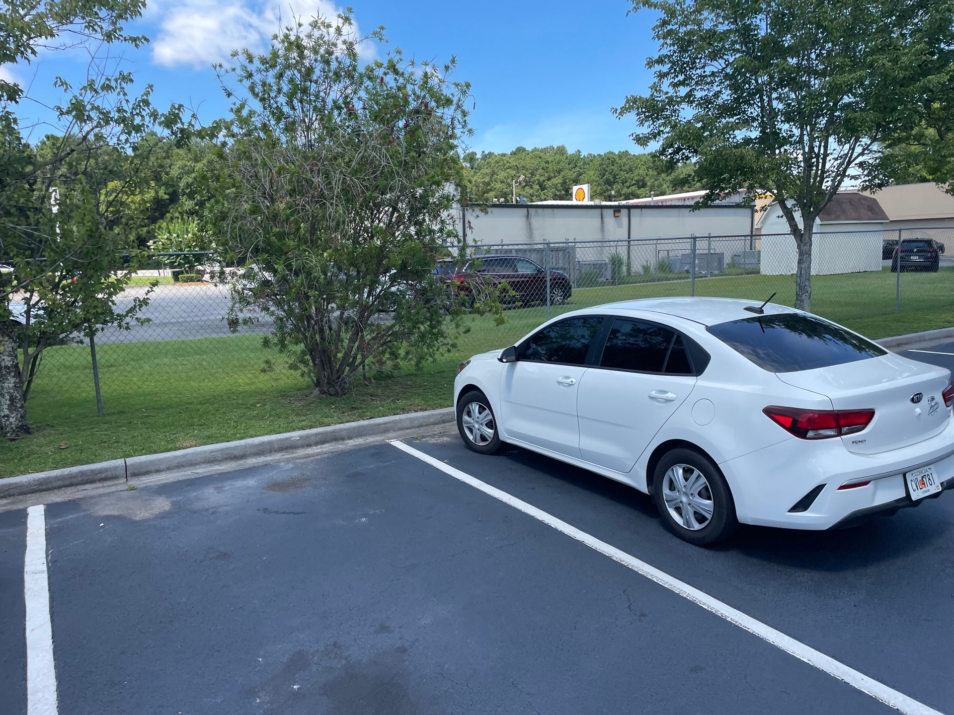 A white car is parked in a parking lot.