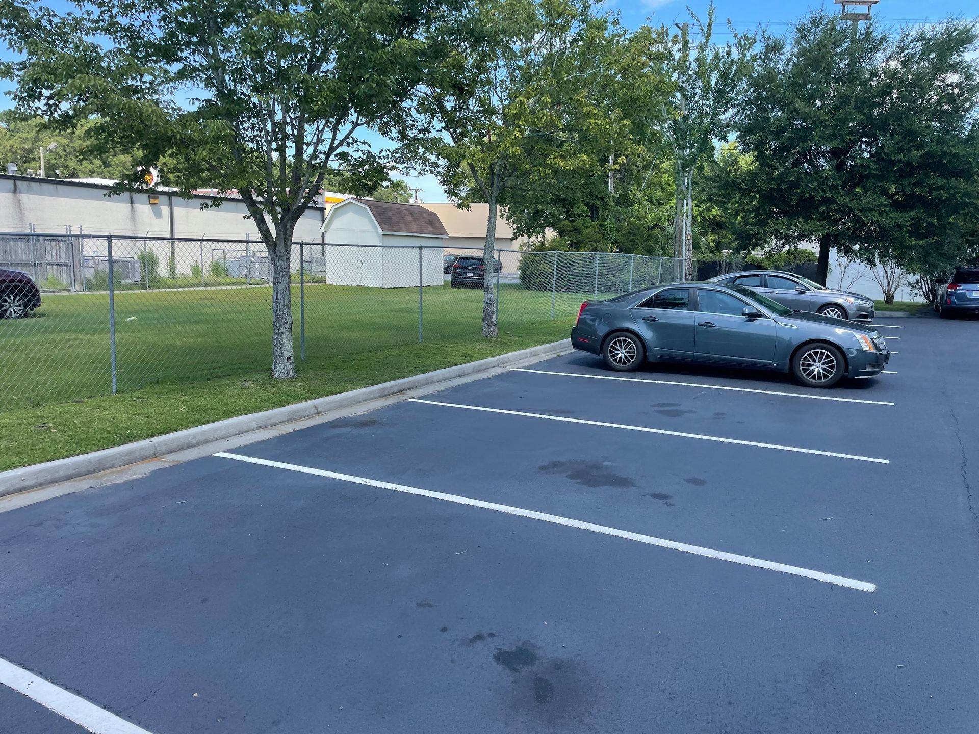 A row of cars are parked in a parking lot.