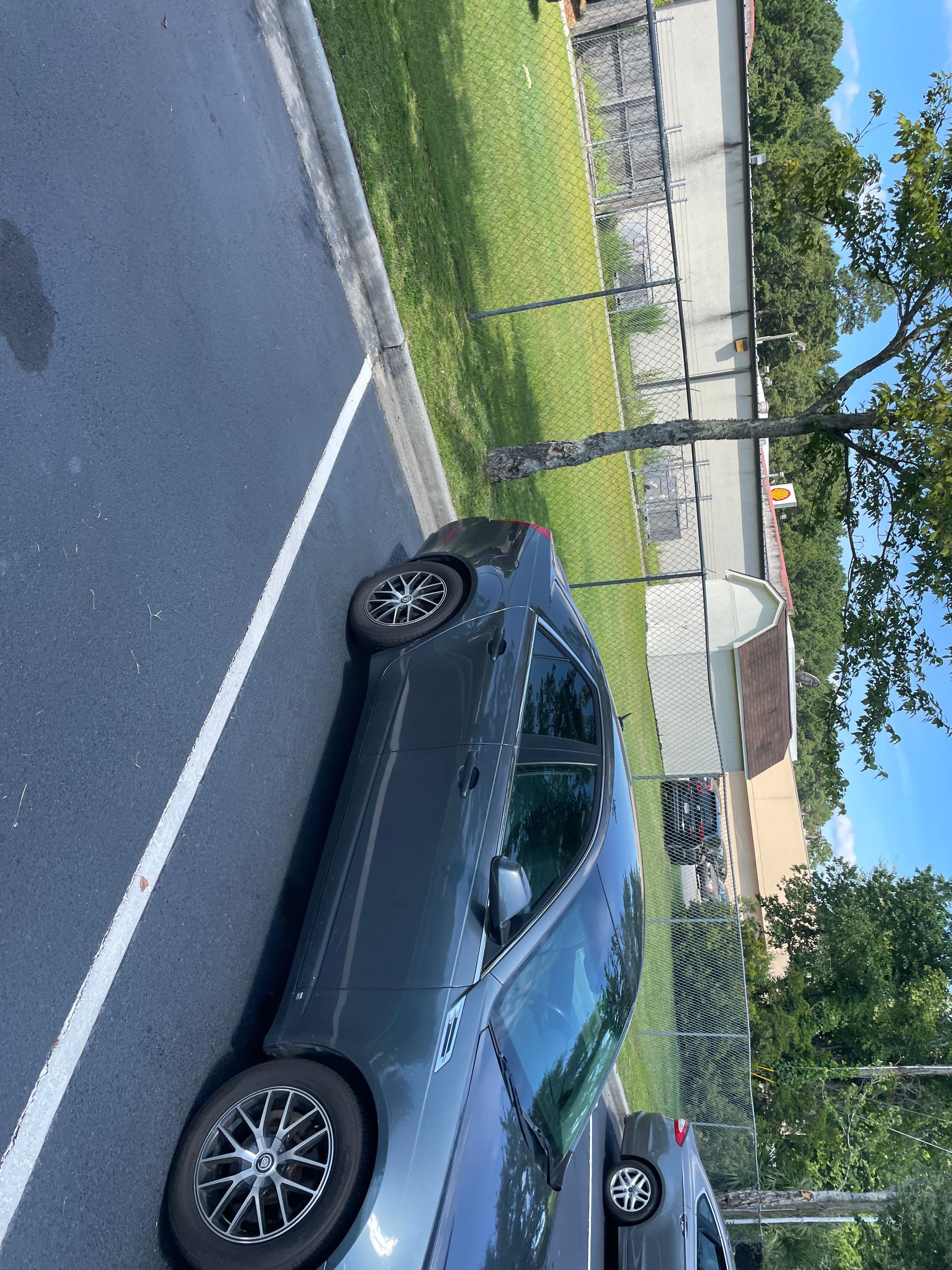 A car is parked on the side of the road in a parking lot.